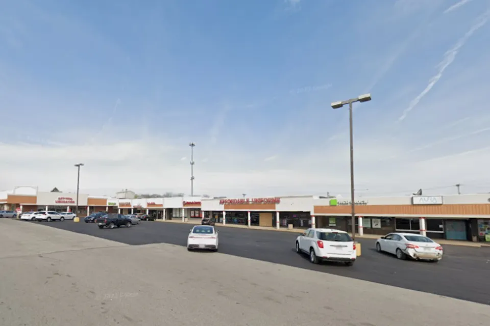 Google Maps view of one-story shopping center with large parking lot.